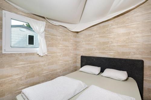 a small room with a bed and a window at Camping 2000 in Januv Dul