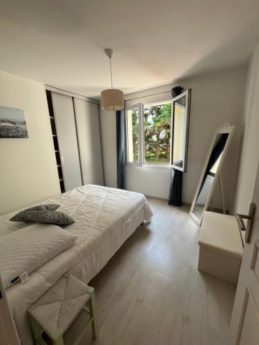 Un dormitorio con una cama y una ventana grande. en Maison Familiale 6 pers - Orouët, en Saint-Jean-de-Monts