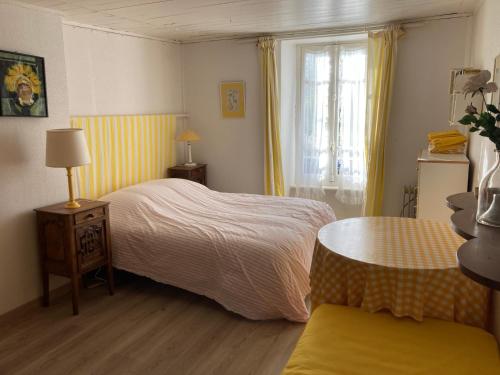 une chambre avec un lit, une table et une fenêtre dans l'établissement Maison artistes bord de mer Rostellec, à Crozon