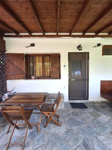 a wooden table and chairs on a patio at Gatzea Delfini in Kato Gatzea