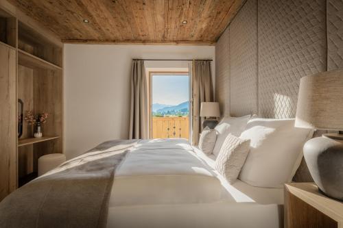 a bedroom with a large white bed with a window at Arnestgut in Strobl