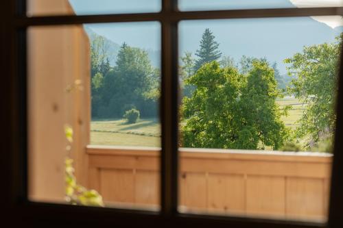 a window with a view of a field and trees at Arnestgut in Strobl