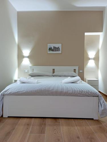 a white bedroom with a white bed and wooden floors at Il Ponticello in Gradillo