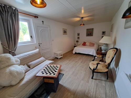 ein Wohnzimmer mit einer Couch und einem Schachbrett in der Unterkunft Pause zen dans le Perche Nature & calme 