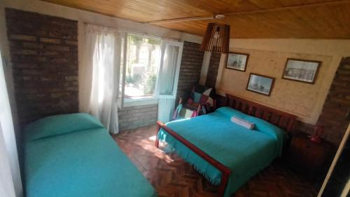 une petite chambre avec un lit et une fenêtre dans l'établissement Fox Den, à Luján de Cuyo
