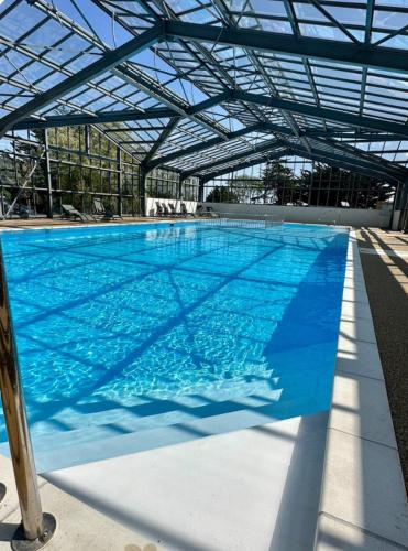 une grande piscine avec de l'eau bleue dans l'établissement COTTAGE 2chambres-piscine-mer-plages-pistes cyclables, à Guérande