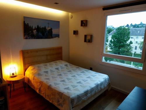 une chambre avec un lit et une grande fenêtre dans l'établissement Studio, à Chambéry