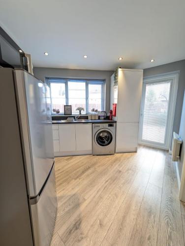 a kitchen with a refrigerator and a washer and dryer at LuxeView - Stylish & Comfortable 1 Bedroom House in Chafford Hundred in North Stifford