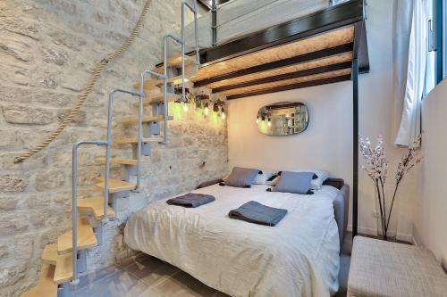 une chambre avec un lit dans un mur de briques dans l'établissement Studio walking distance from Marais with mobile AC, à Paris