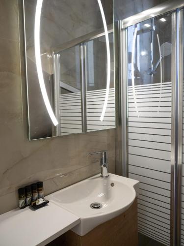 a bathroom with a sink and a mirror at St Nickolas Guest House in Artemida
