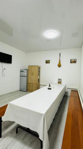 a large white bed in a room with a refrigerator at Deutsch Hostel Osh in Osh