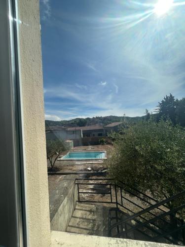 Elle offre une vue sur la piscine depuis sa fenêtre. dans l'établissement La Maison Des Oliviers, à Saint-Hilaire