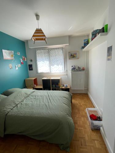 una camera da letto con un letto, una scrivania e una finestra di Appartement familiale Paris - Mairie des Lilas a Les Lilas
