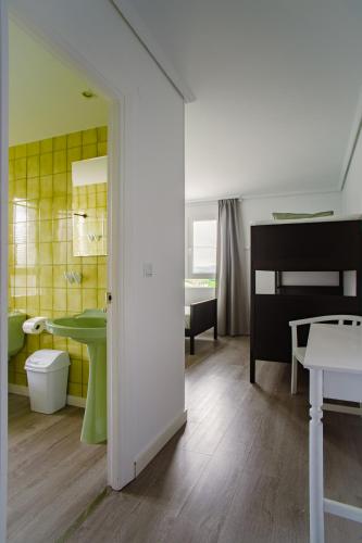 a bathroom with a green sink and a toilet at H.A.N.D Surf Hostel in Langre