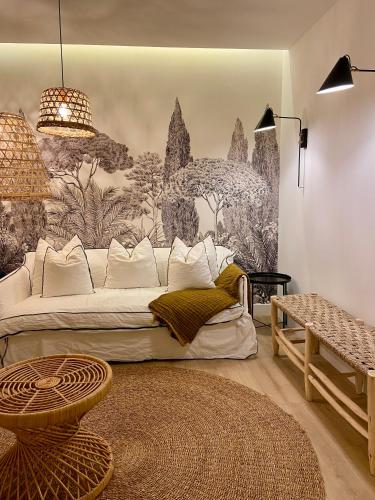 un salon avec un canapé blanc et une fresque murale. dans l'établissement Les Suites de Collioure, à Collioure