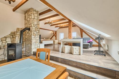 a living room with a stone fireplace and a dining table at Havlovice, ubytování u dřevěné Lávky, okres Trutnov in Havlovice
