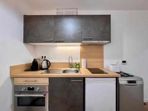une cuisine avec un évier et un plan de travail dans l'établissement Piccolo Studio, logement neuf avec parking gratuit, à Saint-Valery-sur-Somme