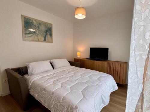 - une chambre avec un grand lit et une télévision dans l'établissement Piccolo Studio, logement neuf avec parking gratuit, à Saint-Valery-sur-Somme