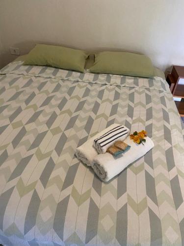 a bed with a blanket and towels on it at Estrela dos Lençóis in Atins