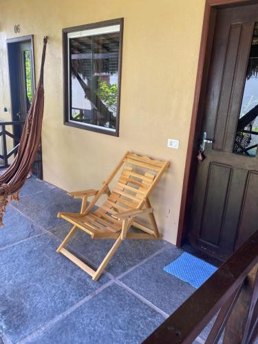 a rocking chair on the porch of a house at Estrela dos Lençóis in Atins