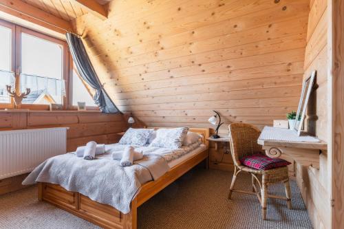 a bedroom with a bed in a wooden room at Apartament z widokiem w Murzasichlu in Murzasichle
