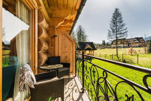 a balcony with a table and chairs on a house at Apartament z widokiem w Murzasichlu in Murzasichle