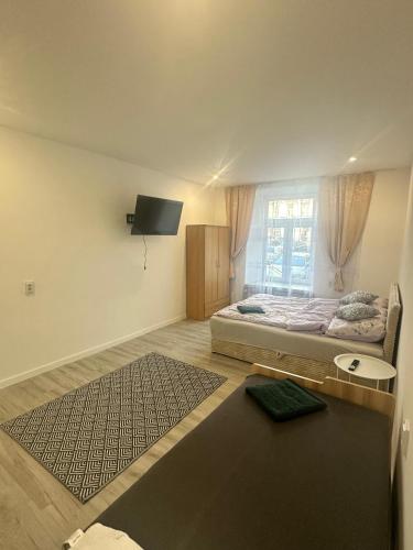 a bedroom with a bed and a tv on the wall at Hostel w samym Centrum Radomia ! in Radom