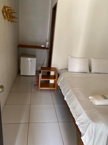 a small room with a bed and a chair at Estrela dos Lençóis in Atins