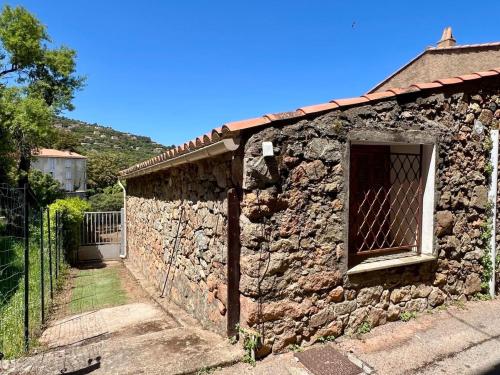 un bâtiment en pierre avec une porte et une clôture dans l'établissement Bergerie corse avec vue mer, à Piana