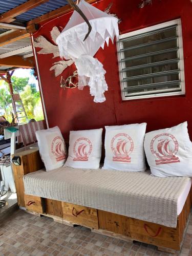 a bed in a room with pillows on it at la maison des bois flottés in Port-Louis