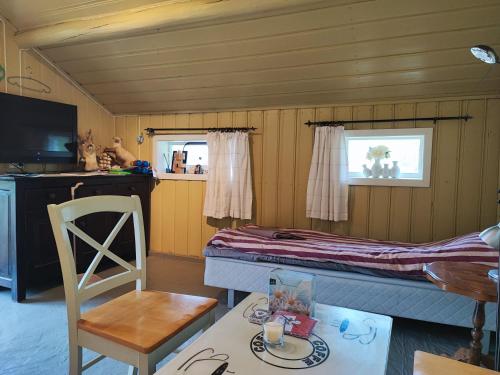 a room with a bed and a table and a chair at Bie huset 