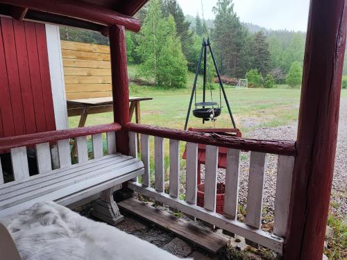 a porch with a bench and a swing at Bie huset 