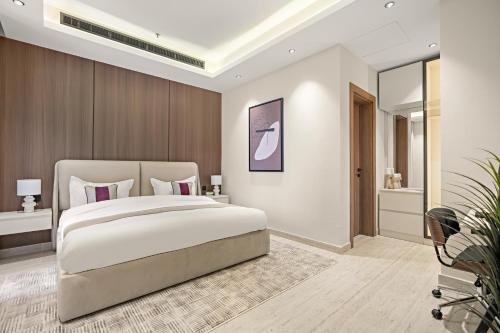 a bedroom with a large bed and a bathroom at LIV by Yamama - KAFD in Riyadh