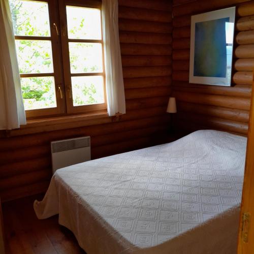une chambre avec un lit et deux fenêtres dans l'établissement Chalet de montagne Las Trinquades, à Boussenac