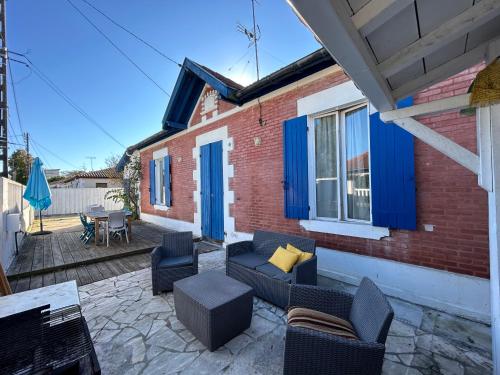 d'une terrasse avec un canapé, des chaises et une table. dans l'établissement L'Arcachonnaise, à La Teste-de-Buch