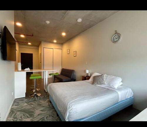 a bedroom with a bed and a chair and a table at Apartamento Vista 11 URBN Escalante in San José