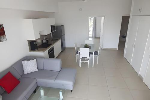 ein Wohnzimmer mit Couch und Tisch und eine Küche in der Unterkunft Departamento Hanna #7 Bucerias in Bucerías