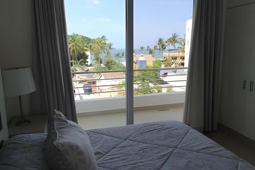 ein Schlafzimmer mit einem Bett und einem großen Fenster in der Unterkunft Departamento Hanna #7 Bucerias in Bucerías