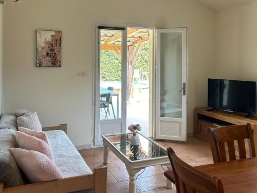a living room with a couch and a glass table at Le gîte les chênes piscine privée et jacuzzi in Servas