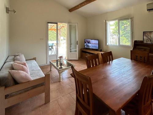 a living room with a wooden table and a dining room at Le gîte les chênes piscine privée et jacuzzi in Servas