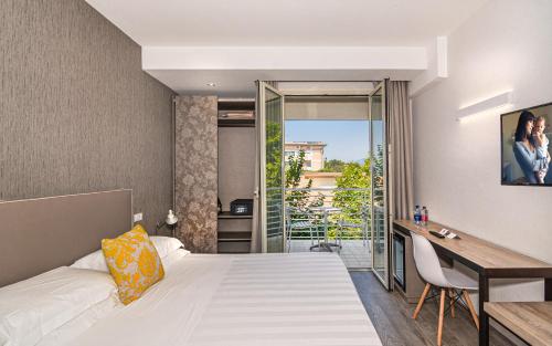 a hotel room with a bed and a desk at Hotel Joseph in Marina di Pietrasanta