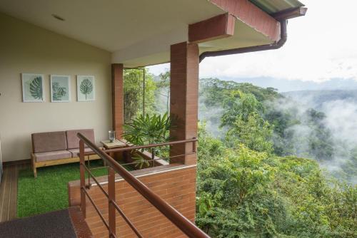 a room with a balcony with a view of the forest at Vibra Healing Lodge y Spa in Teniente Hugo Ortiz