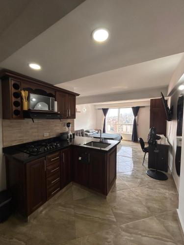 a kitchen with a sink and a stove top oven at Hermoso loft en medellin in Medellín