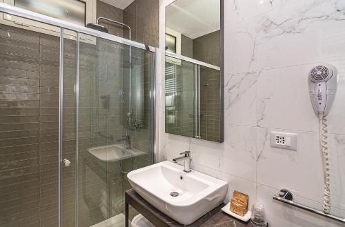 a white bathroom with a sink and a shower at Hotel Joseph in Marina di Pietrasanta