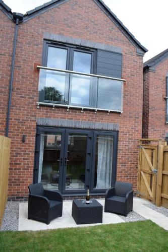a brick house with two chairs and a table at Tolson Court House in Fazeley