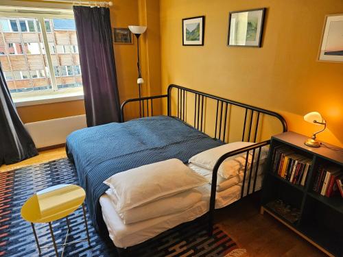 a bedroom with a bed and a chair and a window at Sigurd's Loft in Vossevangen