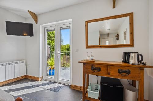 a room with a mirror and a wooden table with a sink at Trewethen Cottage Barn 2 near Port Isaac in Port Isaac