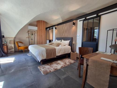 une chambre avec un lit et un bureau dans une pièce dans l'établissement Côté Tour, à Orcet