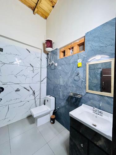 a bathroom with a sink and a toilet in it at Lotus Lake View Inn in Bhīm Tāl
