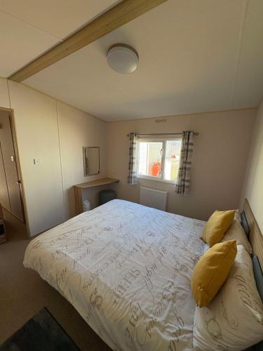 a bedroom with a large white bed with yellow pillows at Biggerstaffs retreat in Lossiemouth